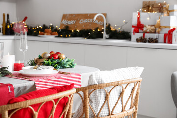 Christmas table setting with burning candles and wreathes