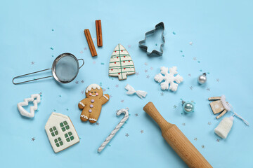 Christmas gingerbread cookies, baking mold and rolling pin on blue background