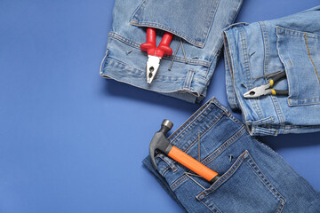 Jeans with different tools in pockets on blue background. Labor Day celebration