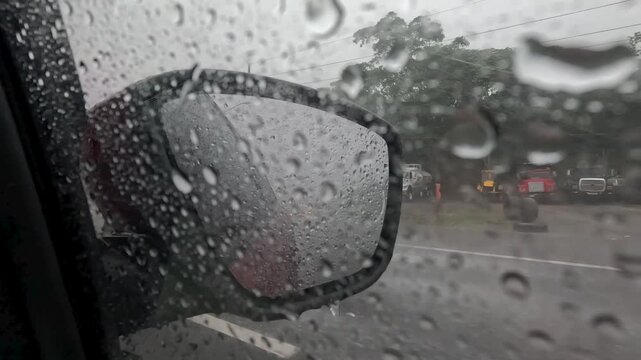 Rodando por carretera en un d&iacute;a lluvioso, vista desde el retrovisor de un auto.