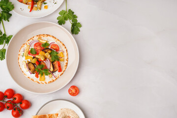 Plate of tasty pita bread with grilled vegetables on white background