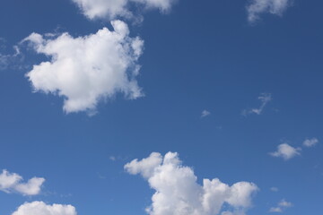 white puffy clouds floating against deep blue skies