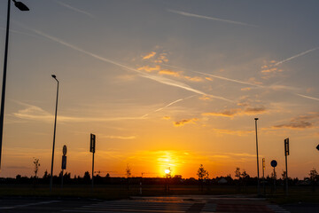 Serene sunset over a highway with silhouettes of road signs, capturing the peaceful transition from day to evening in a modern neighbourhood setting. High quality photo