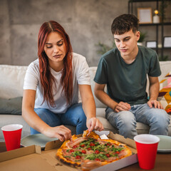 Adult couple take a pizza from pizza box ready for hanging out at home