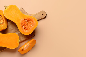Wooden board with fresh pumpkins on brown background