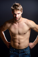 Fototapeta premium Fashion male model. Handsome man with topless body. Muscular model. Strong brutal guy. Portrait of handsome sport model. Handsome young man with naked body posing in studio. Sexy male model.