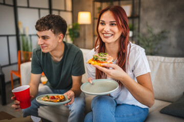 Adult couple boyfriend and girlfriend hanging out at home eat pizza