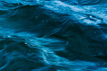 Macro blue wave pattern in a river with motion blur
