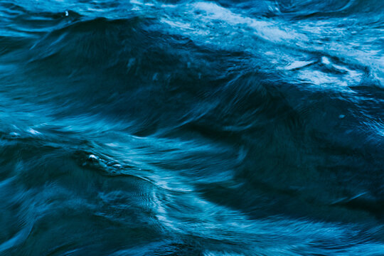 Macro blue wave pattern in a river with motion blur
 - Powered by Adobe