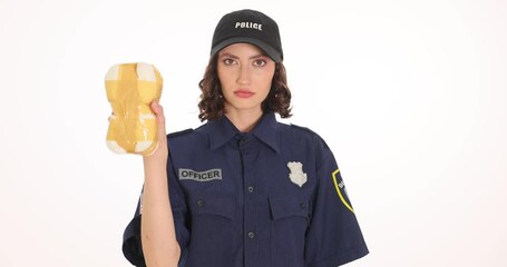 Female police officer shows confiscated brick of drugs alongside pair of handcuffs on white background. Woman performs fight with crimes