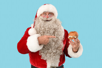 Shocked Santa Claus pointing at tasty burger on blue background