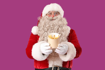 Santa Claus with tasty french fries on purple background
