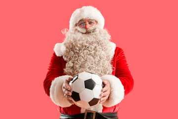 Santa Claus with soccer ball on red background