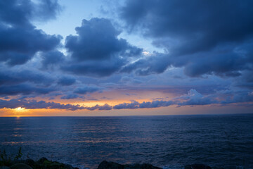 The sky is cloudy and the sun is setting