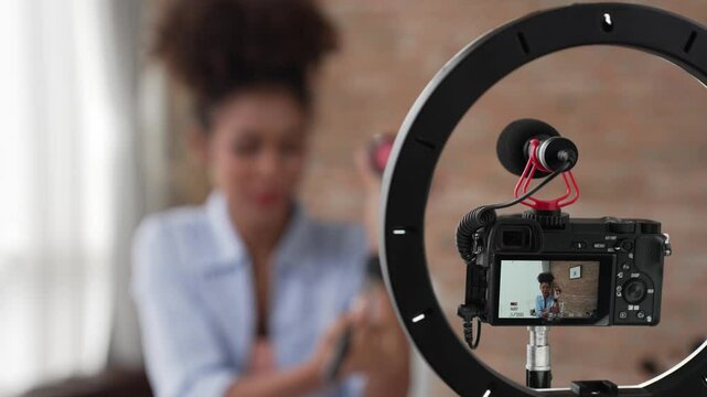 Rear view camera screen recording woman influencer shoot live streaming vlog video review makeup crucial social media or blog. Girl with cosmetic studio lighting for marketing broadcasting online.