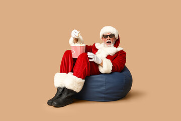 Shocked Santa Claus in 3D glasses with bucket of tasty popcorn on brown background