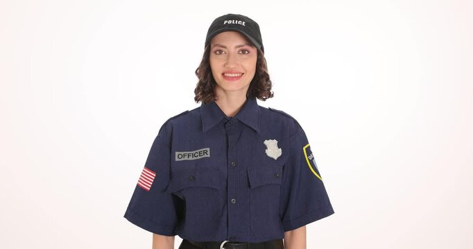 American policewoman in uniform and cap smiles standing on white background. Female offices expresses happiness performing justice power