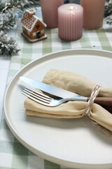 Christmas place setting with festive decor on white table, closeup