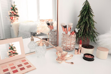 Makeup brushes and perfume on white table indoors