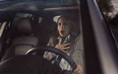 Shocked woman sitting in car