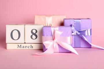 Cube calendar with date 8 MARCH and gift boxes on pink background. International Women's Day