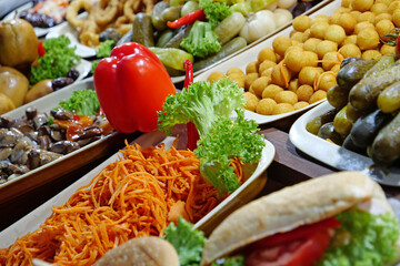 Foods in supermarket deli - mushrooms, salads, pickle, carrot, marinade