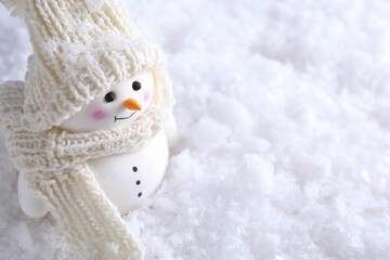 Cute decorative snowman on artificial snow, closeup. Space for text