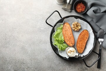 Tasty cooked sweet potato in baking dish served on grey textured table, flat lay. Space for text