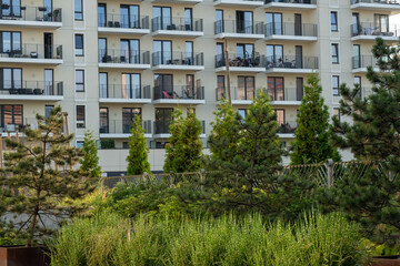 Extensive flowerbeds with vibrant greenery in a modern residential complex. Concept of urban landscaping, sustainable greenery, and contemporary urban living. High quality photo