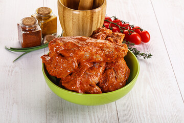 Raw turkey shoulder wing in Indian tandoori marinade