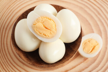 Bowl with fresh boiled quail eggs on wooden background