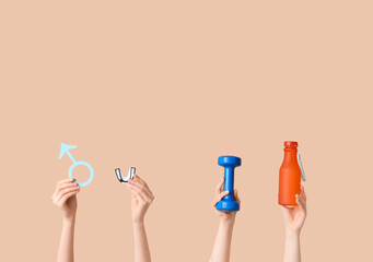 Female hands with male sign, mouth piece, dumbbell and water bottle on beige background. Prostate cancer concept