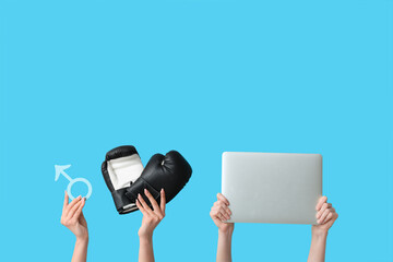 Female hands with male sign, boxing gloves and laptop on blue background. Prostate cancer concept