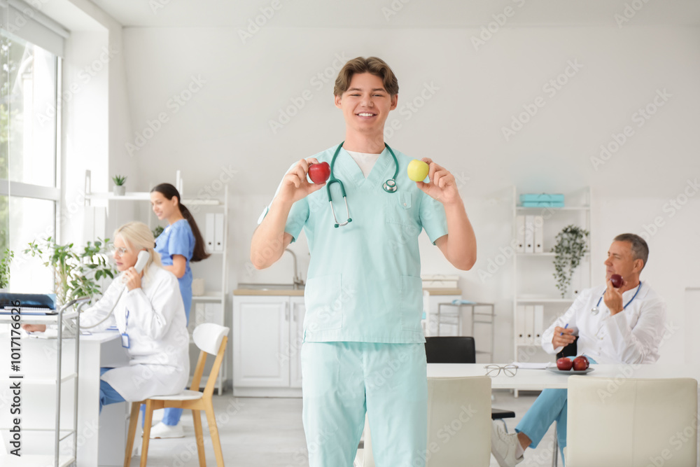 Sticker Young male doctor with apples in clinic