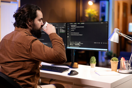 Engineer drinking coffee in the morning and futureproofing company network from downtimes and unexpected system failures. IT admin enjoying hot beverage while increasing data security
