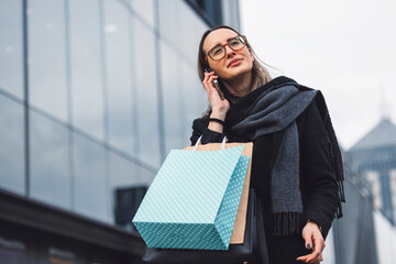 Young woman outside a shopping centre with bags of shopping