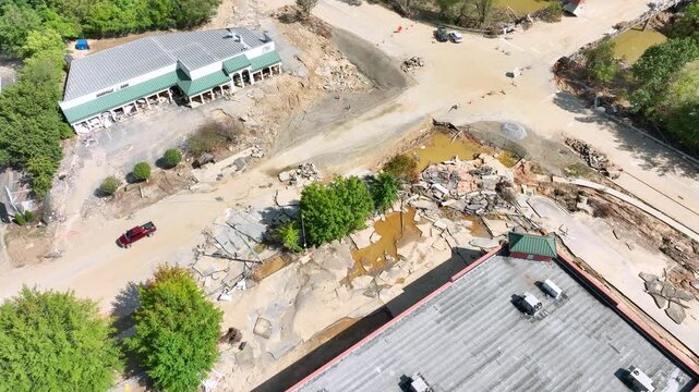 Aerial video of devastated parking lot and businesses after 1 week, in the aftermath of tropical storm Helene, Asheville, NC.