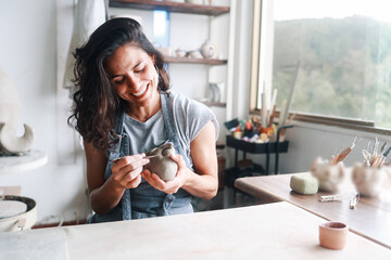 Art business, Artist work with ceramic at clay pottery workshop studio. Woman doing sculpture....