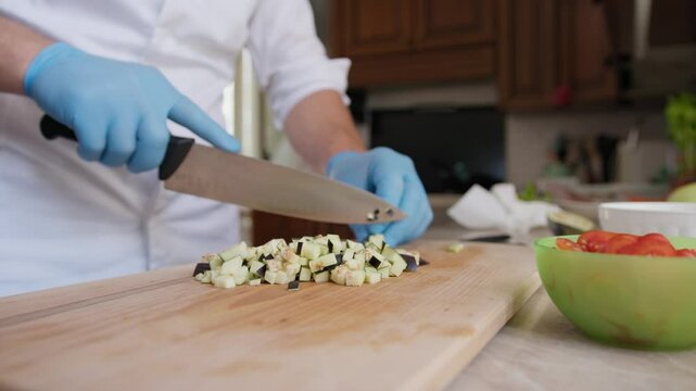 Chef Cuts An Eggplant Food Into Brunoise On Wooden Cutting Board
