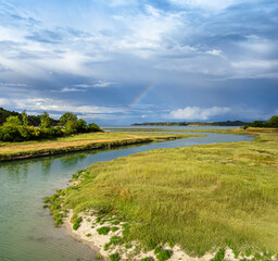 Scenic Marshland in Brittany with Rainbow and Calm Waters