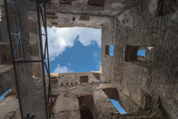 Malownicze ruiny zamku na tle błękitnego nieba letniego dnia. W „ramach” murów zamku widoczny jest piękny obraz letniego błękitnego nieba z białymi, drobnymi, delikatnymi chmurami. © Grzegorz