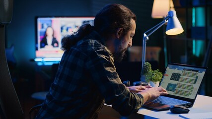 Self employed man checking statistical data financial graphs on laptop screen, researching...