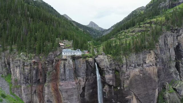Powerhouse and Bridal Veil Falls near Telluride, Colorado. Wide angle, rotating pan shot that shows the powerhouse, waterfall, and very rugged cliffs of the area.