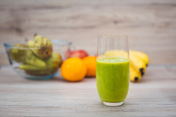 Healthy eating lifestyle concept photo of young woman preparing drink with fruit and vegetables at home in kitchen.