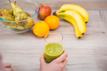 Healthy eating lifestyle concept photo of young woman preparing drink with fruit and vegetables at home in kitchen.