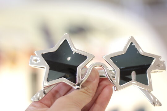 A close-up prop concept photo of a star-shaped sun grass held by a woman's hand.