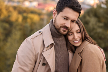 Beautiful couple hugging in park on autumn day