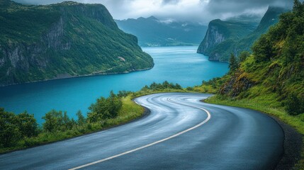 Winding road through a mountain valley with a fjord in the backg