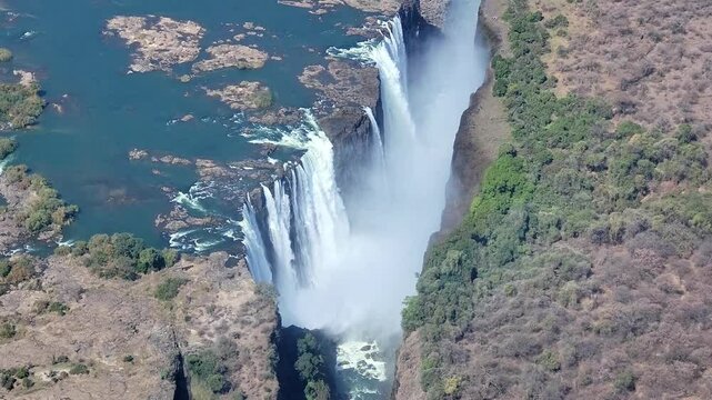 Victoria Falls is a waterfall on the Zambezi River, located on the border between Zambia and Zimbabwe. It is one of the largest waterfalls in the world, viewed from a helicopter.