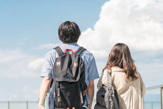 大学・短大・専門学校の校舎・屋上を歩く男女カップル・同級生の学生
